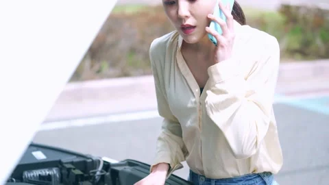 Young asian woman opening bonnet of vehicle. Road service. Roadside assistance. Stock Footage