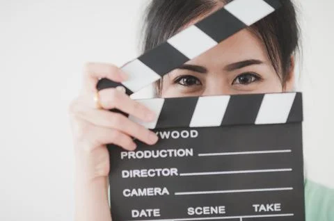 Young Asian woman playing clapperboard with positive emotion Stock Photos