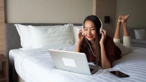 A young Asian woman prone on the bed of ... | Stock Video | Pond5