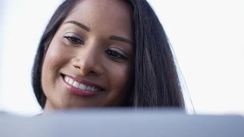 Young asian woman reading her laptop outdoors and smiling Stock Photos