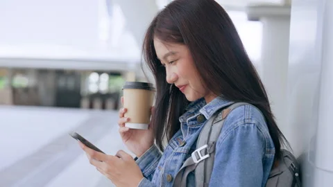 Young asian woman using mobile in city. Happy female tourist wearing jeans .. Stock Footage 240964292