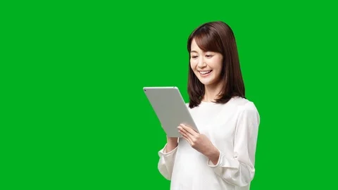 Young asian woman using tablet pc. Green background for Chroma keying. Stock Footage 101370436