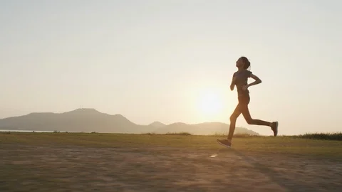 Young Asian women are exercising outdoor running with a mountain background. Stock Footage