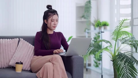 Young Asian women freelancer using laptop computer work from home sitting o.. Stock Footage 334358573