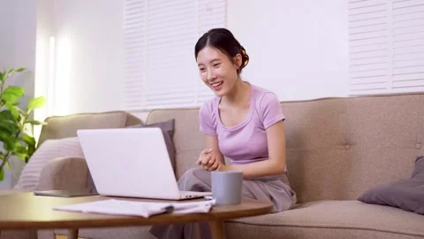 Young Asian women remote work from home using laptop computer video call on.. Stock Footage 334368853