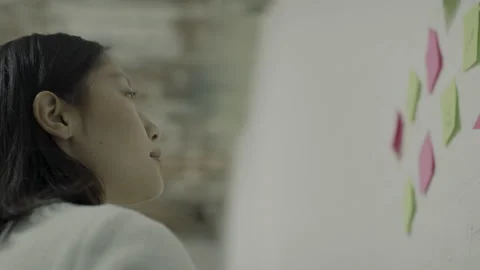 Young Asian writing notes on wall 스톡 동영상 146926832