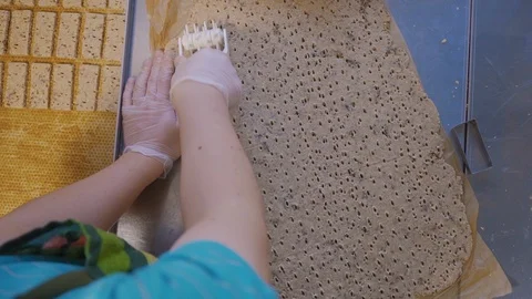 Young assistant cook makes perforations, holes in the dough. View from above Stock Footage 125956598