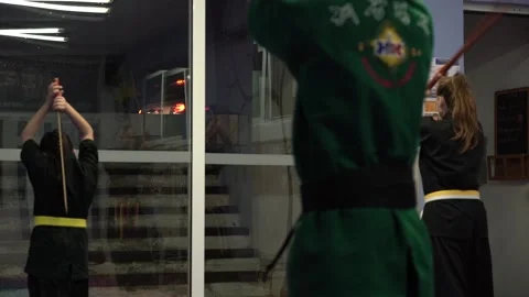 Young atheletes practicing tae kwon with a sword do in a small group due to  Stock Footage 142120717