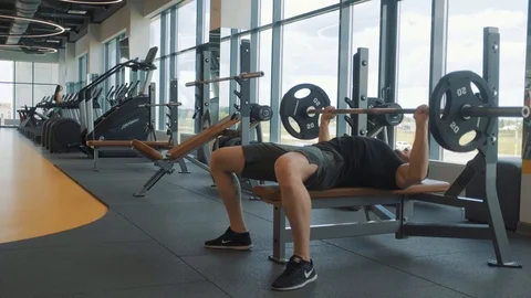 Young athlete. bench press lying. man goes in for sports in an empty gym Stock Footage 113273191