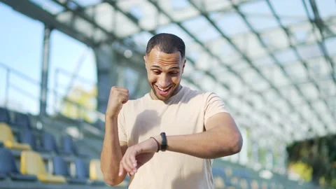 A young athlete checks the results of training on a smart watch in an urban city Stock Footage 234880739