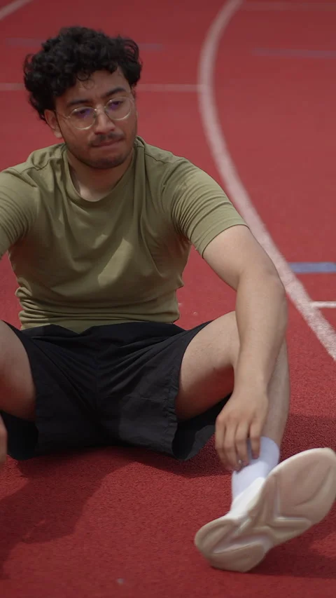 Young Athlete Doing Stretching Exercises on Track Field Before Their Stockbeeldmateriaal 295893252