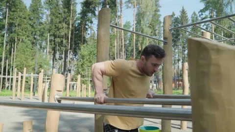 Young athlete doing triceps push-ups on parallel bars Stock Footage 250126668