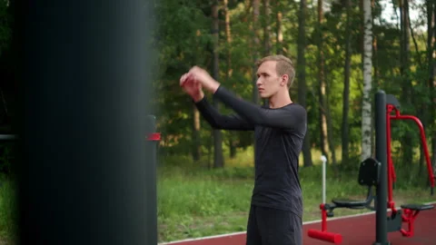 Young athlete doing upper body warm up routine before a workout at an outdo.. 動画素材 341728869