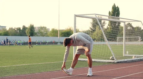 Young athlete doing a warm up leg stretch before a race Stock Footage 54576963
