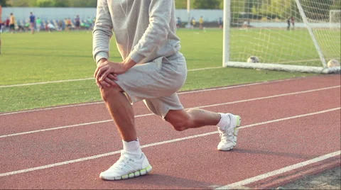 Young athlete doing a warm up leg stretch before a race. Stock Footage 54579757