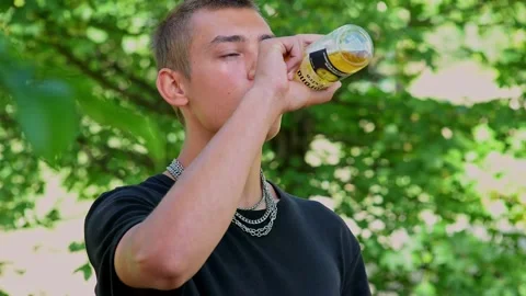 Young athlete drinks water and exercises outdoors Stock Footage 228665475