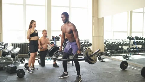 Young athlete going to do exercises with heavy barbell Stock Footage 148265174