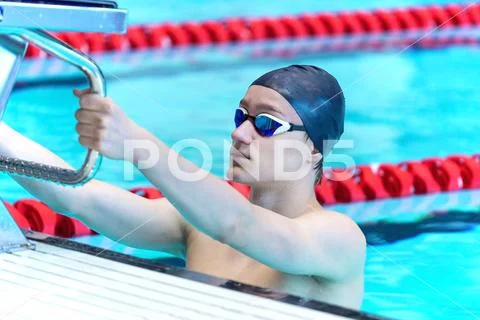 A young athlete is holding a starting platform. Stock Photos