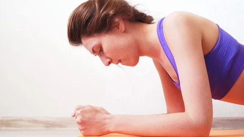 Young athlete makes efforts and perseverance when doing the plank. It is Stockbeeldmateriaal 128976036