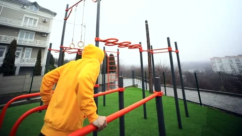 Young athlete man doing exercises on pull-up horizontal bar outside enjoying hea 스톡 동영상 166090499