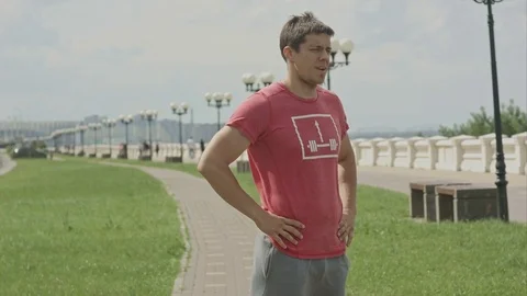 Young athlete man doing stretching warming up before jogging outdoors Видео 80051395