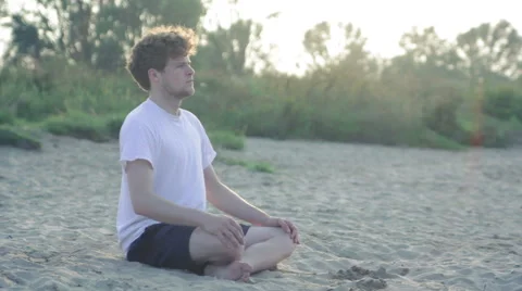 Young athlete meditating at the beach Stock Footage 40763172