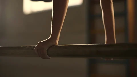 A young athlete performs a gymnastic exercise on the wooden parallel bars Stock Footage 205157127