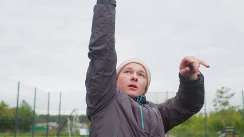Young athlete practices outdoors, Child sports enthusiast shooting under cloudy Stock Footage 329442500