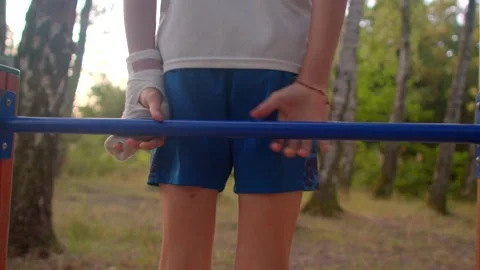 Young athlete practicing dips on outdoor parallel bars in nature Stock Footage 320958585