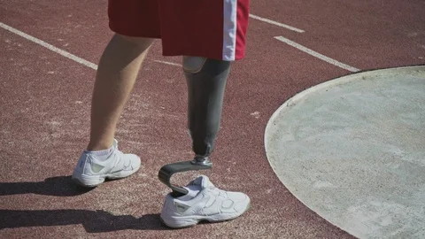 A young athlete on the prosthesis pushes the core in the stadium. Stock Footage 120704550