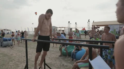 Young Athlete is Pushed on The Parallel Bars during competition on the street Stock Footage 60689598