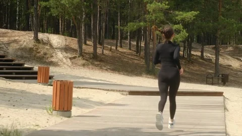 Young athlete running in pine forest, enhancing fitness and achieving goals Stock Footage 311757025