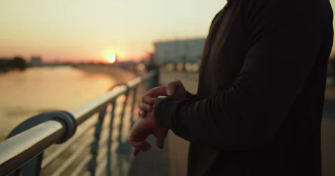 Young athlete using smartwatch after workout in the city at sunset close-up shot Stock Footage 276546079