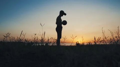 Young athlete in virtual glasses trains basketball at sunset by the lake Stock Footage 115592278