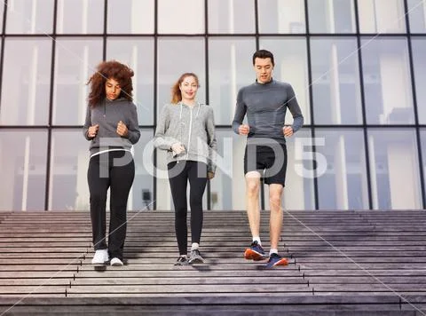 Young athletes going down outdoors on city stairs Stock Photos