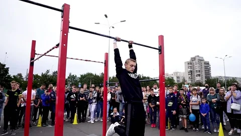 Young athletes show acrobatic stunts on the crossbar Stock Footage 170066574