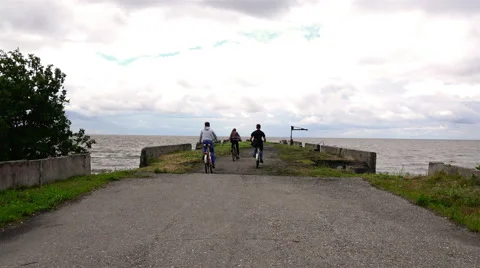 Young athletes at the two bikes I stop on the lake dock in windy weather Stock Footage 68079325