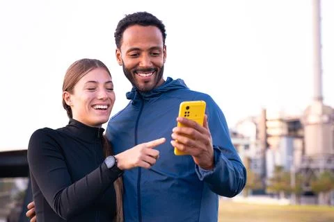 Young athletes using apps on the phone to keep track of their exercise routine. Stock Photos