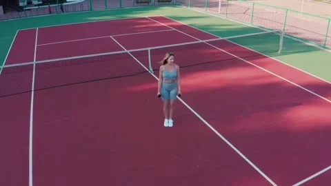 A young athletic blonde doing strength exercises on a sports court. Stock Footage 329147258