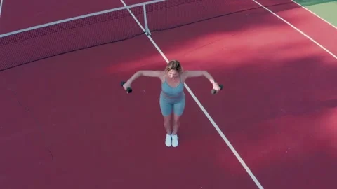 A young athletic blonde doing strength exercises on a sports court. Stock Footage 330327881