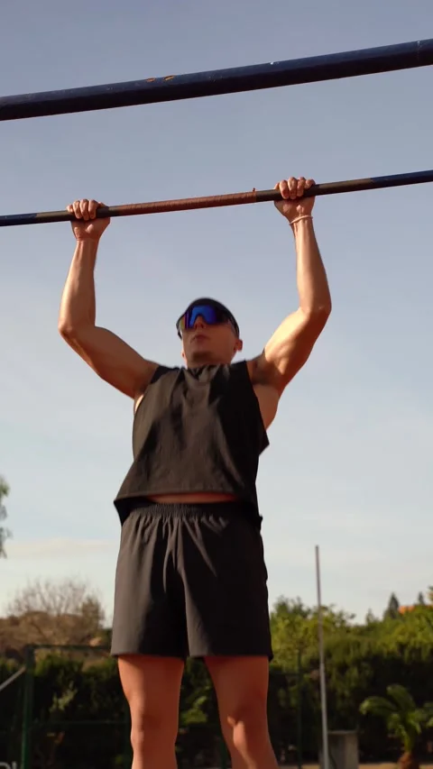 Young athletic boy doing pull-ups on bar. front vertical video. Concept of .. Stock Footage 267894487