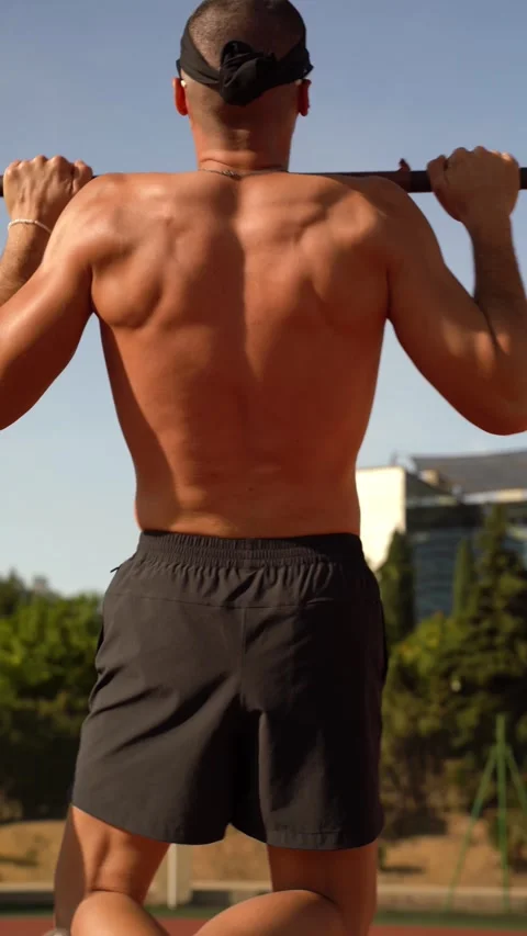 Young athletic boy performs barbell pull-ups with his shirt off. Morning wo.. Stock Footage 267894464