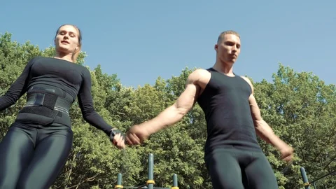 Young athletic couple jumping on the skipping rope outdoors Stock Footage 114563676