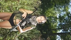 Young girl in short shorts with gun near, Stock Video