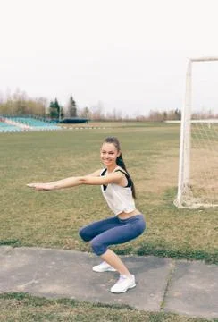 Young athletic girl doing exercise warm up at the stadium Stock Photos