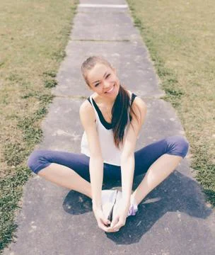 Young athletic girl doing exercise warm up at the stadium Stock Photos