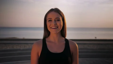 Young athletic girl looking at the camera. Smiling woman standing in front of Stock Footage 208373998