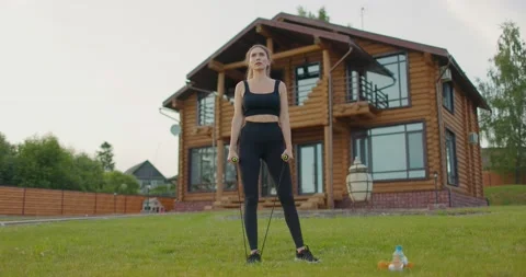 Young athletic girl performs exercises in fresh air against background of Video stock 230991811