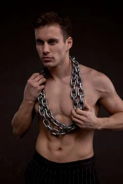 Young athletic guy with chains on his bare torso Stock Photos