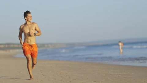 Young athletic lifeguard running on the beach Stock Footage 308191214